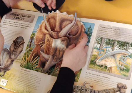 3 Uczniowie oglądają książki z dzinozaurami