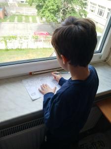 Uczeń rysujący przy oknie