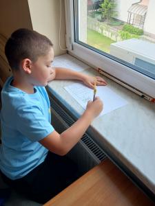 Uczeń rysujący przy oknie - fot. 3